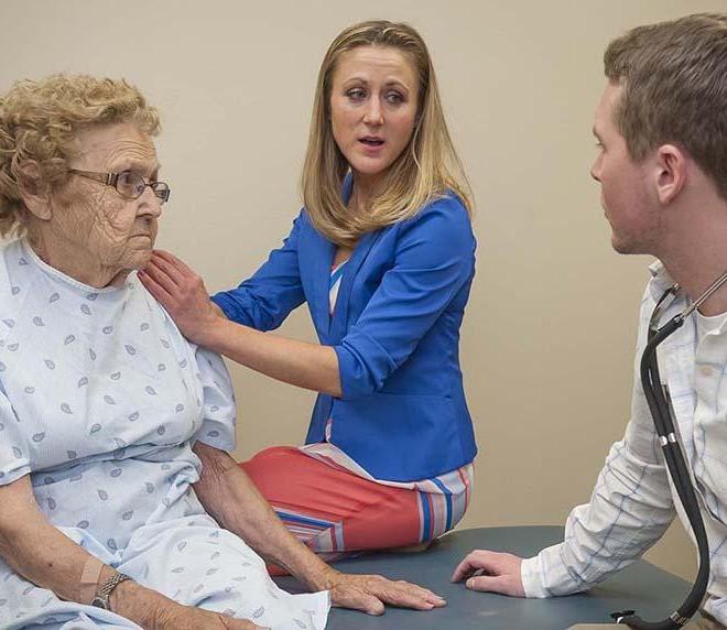 Physical therapy doctoral student and instructor meet with elderly client at the physical therapy clinic